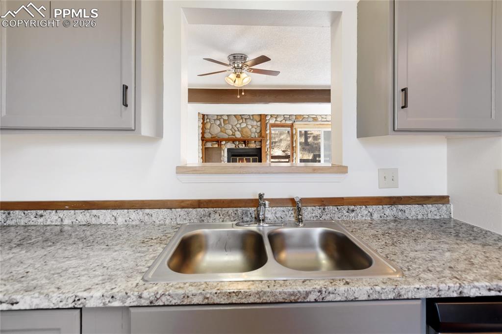 Image 11 of 27: The kitchen features gray cabinets, stainless steel appliances, and light c