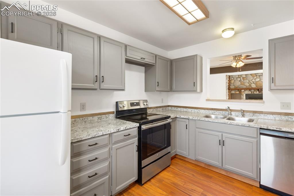 Image 8 of 27: The kitchen features gray cabinets, stainless steel appliances, and light c