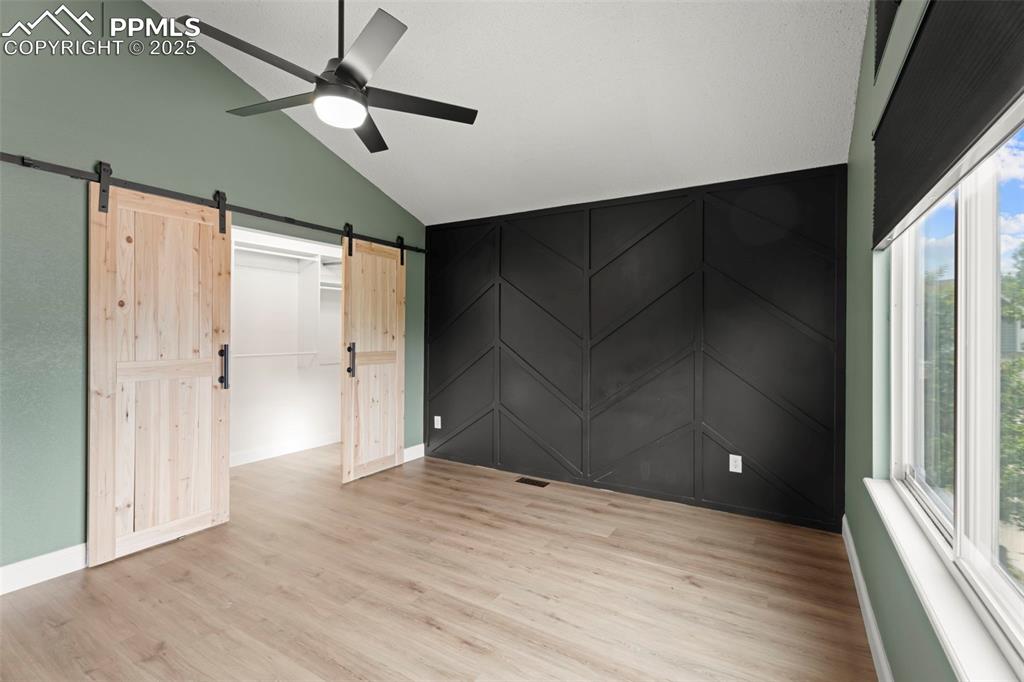 Image 11 of 30: Unfurnished bedroom with light wood-style floors, multiple windows, ceiling