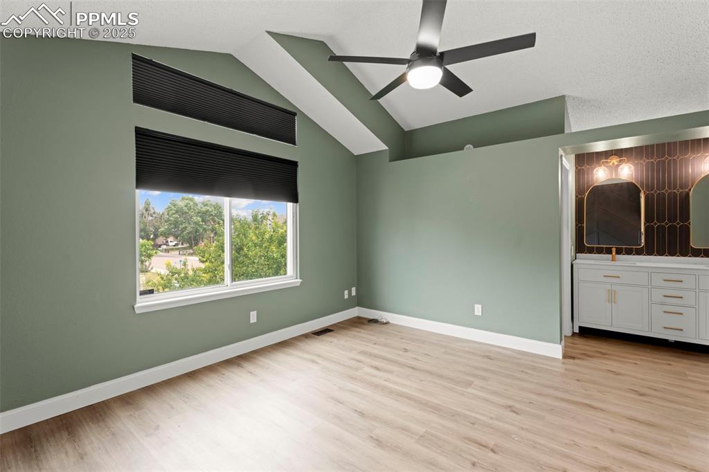 Image 12 of 30: Unfurnished bedroom featuring light wood-style floors and vaulted ceiling