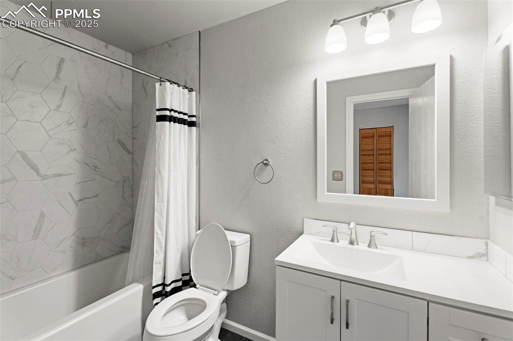Image 18 of 30: Full bath featuring vanity, a textured wall, and shower / bath combination