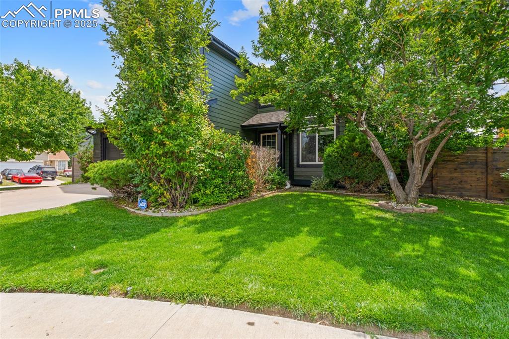 Image 26 of 30: Obstructed view of property featuring a front lawn and a garage