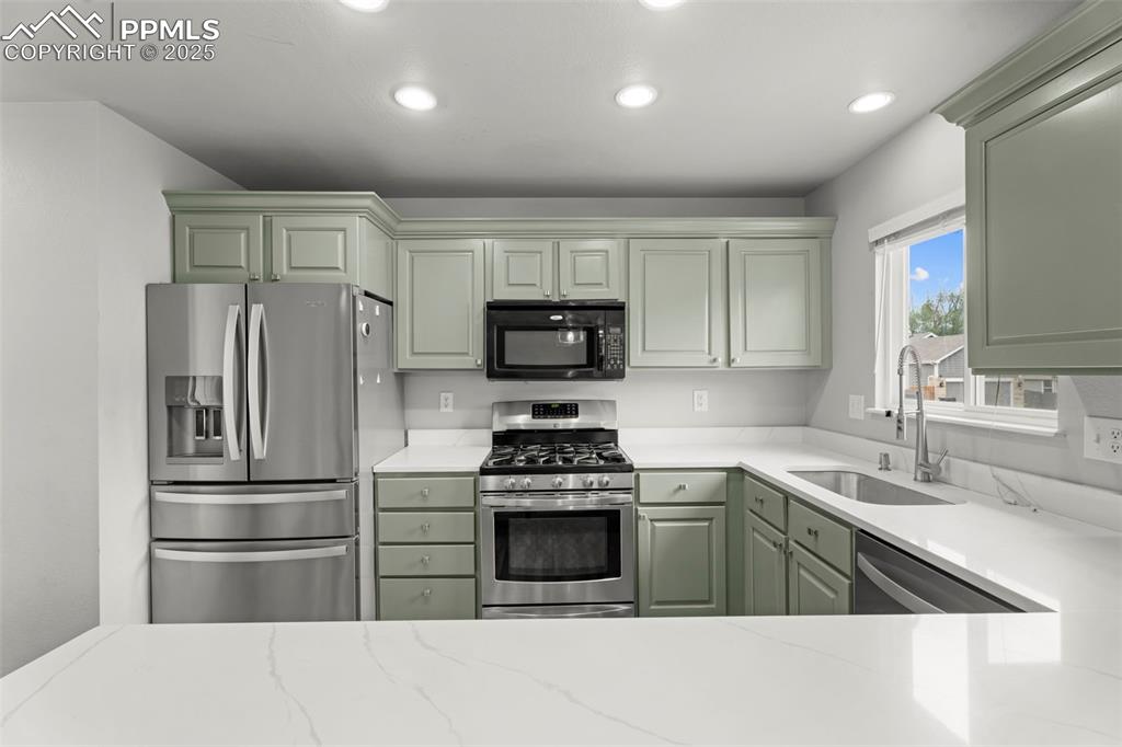 Image 6 of 30: Kitchen featuring stainless steel appliances, recessed lighting, green cabi