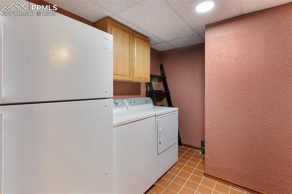 Image 27 of 30: Utility room featuring white top-freezer refrigerator,  washer and dryer, w