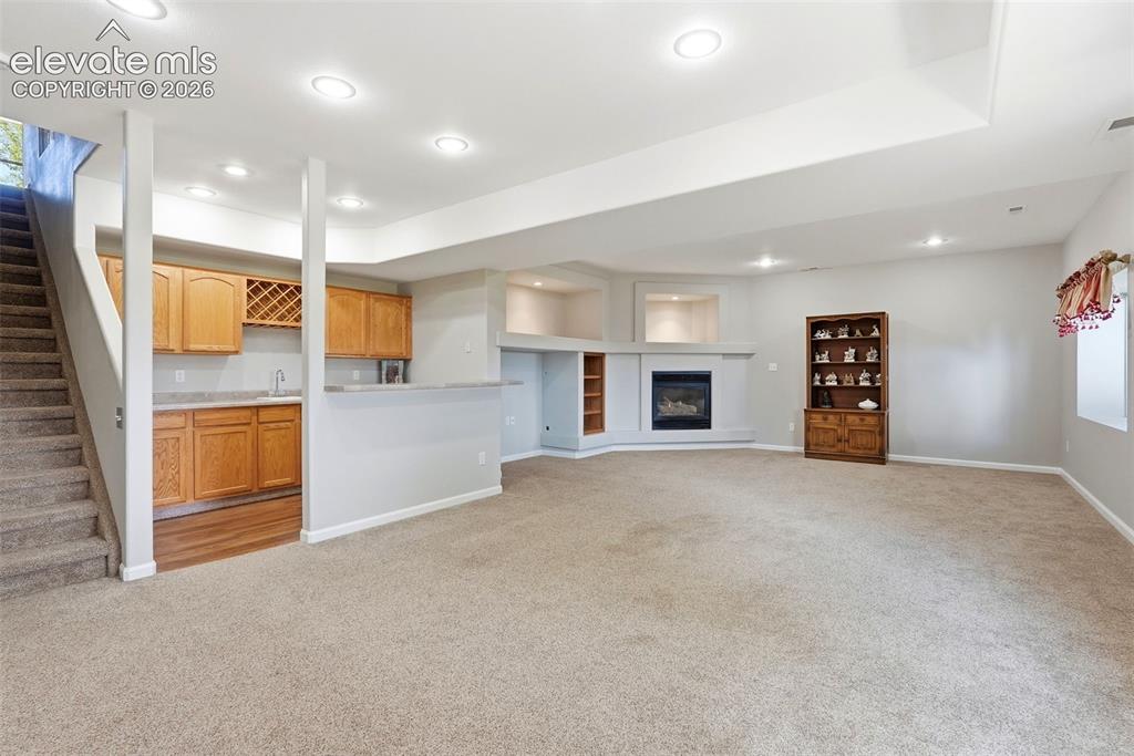 Image 26 of 48: Basement rec/family room with wet bar & fireplace