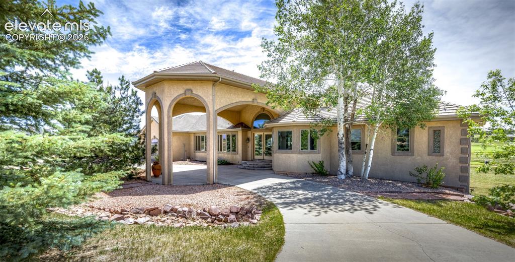Image 1 of 50: Stucco exterior with a covered drive-through portico and arched entryways