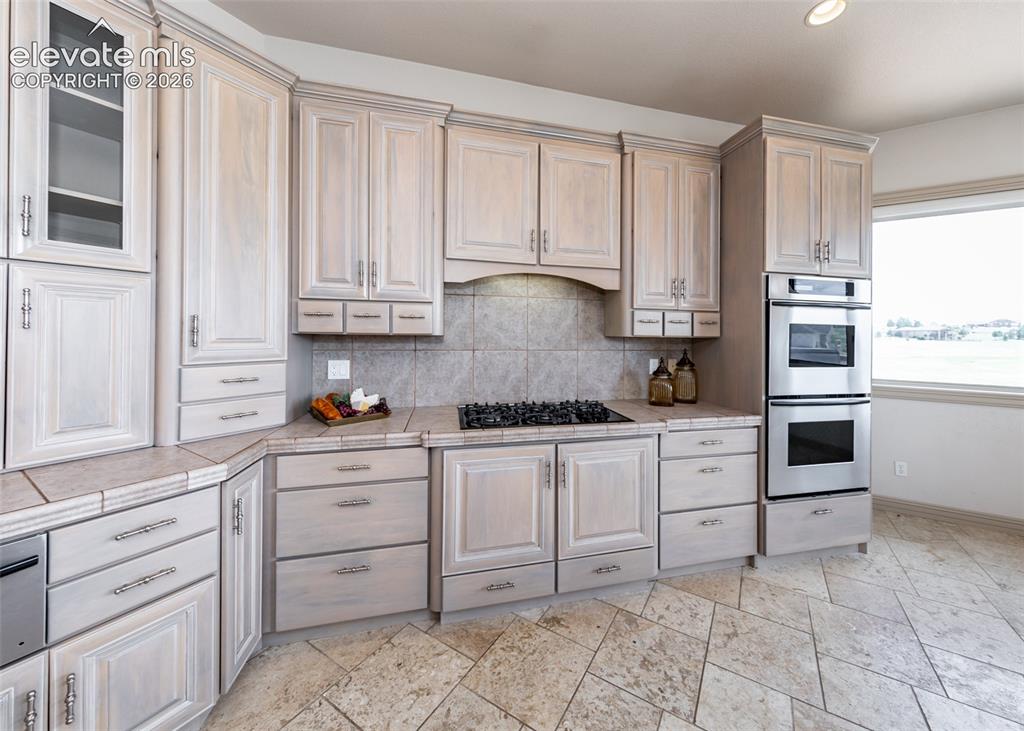 Image 11 of 50: Kitchen featuring light-toned cabinetry, stainless steel double wall ovens,
