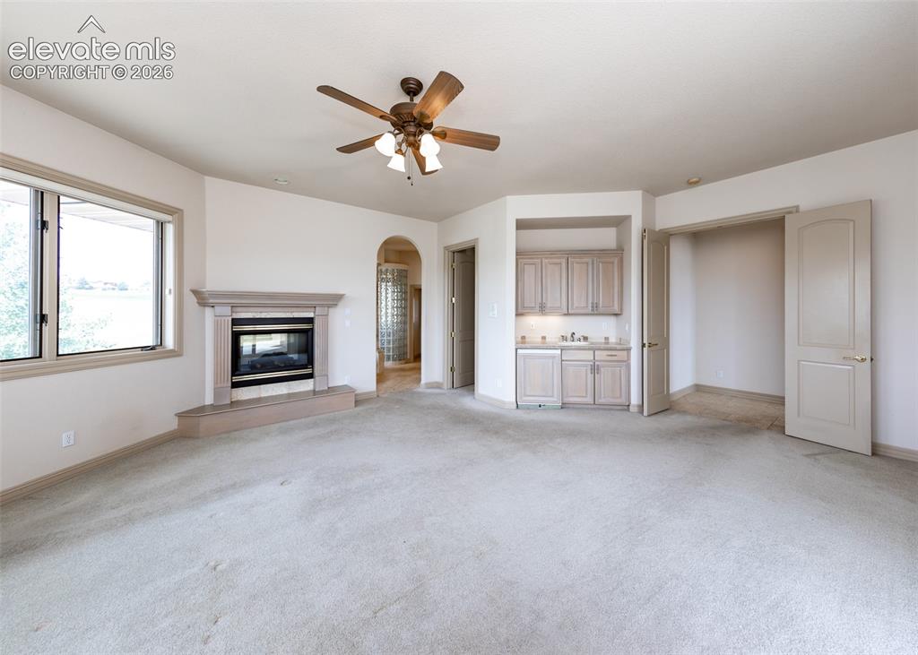Image 20 of 50: Spacious room featuring a built-in fireplace with a stone surround, a ceili