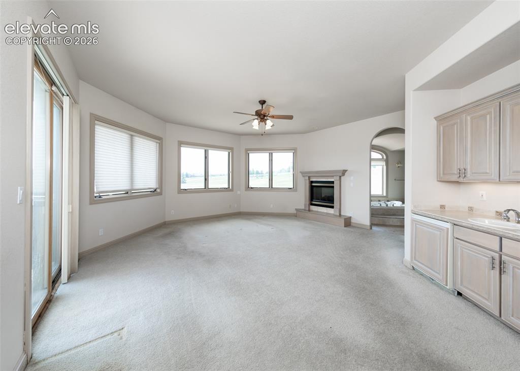 Image 21 of 50: Spacious interior featuring a built-in fireplace, multiple large windows, a