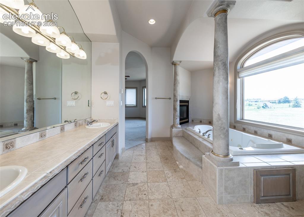 Image 23 of 50: Bathroom featuring a dual vanity with undermount sinks, tile flooring, buil