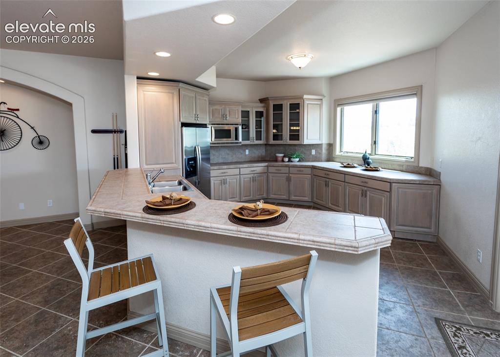 Image 33 of 50: Full kitchen featuring light-toned cabinetry, stainless steel appliances, a