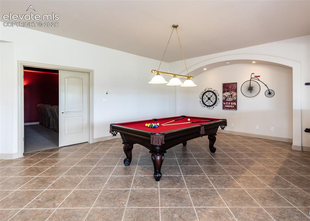 Image 35 of 50: Spacious room featuring diamond-set floor tiling, a recessed arched wall de