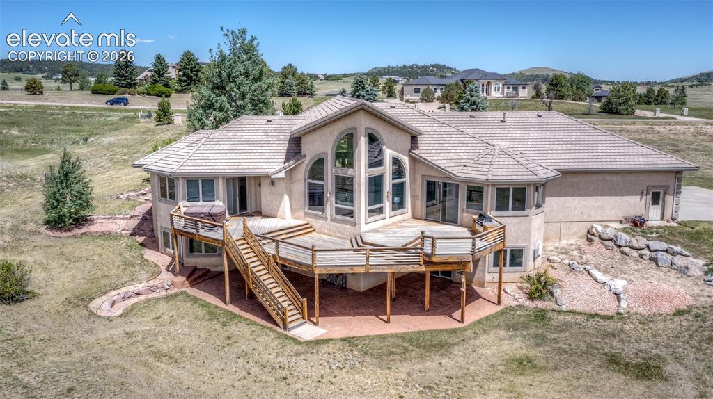 Image 43 of 50: Expansive rear stucco exterior featuring a multi-level wood deck, a patio,