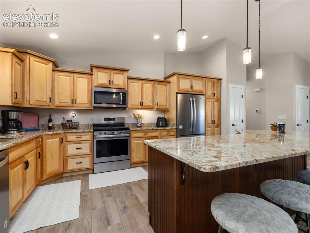Image 10 of 21: Wood-finish flooring, stainless steel appliances, recessed lighting, pendan