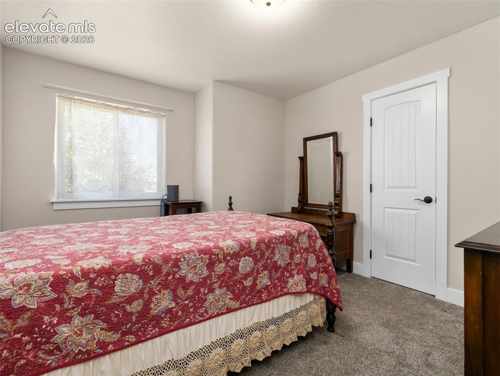 Image 12 of 21: Carpeted flooring, white trim, natural light from a window, and a white int