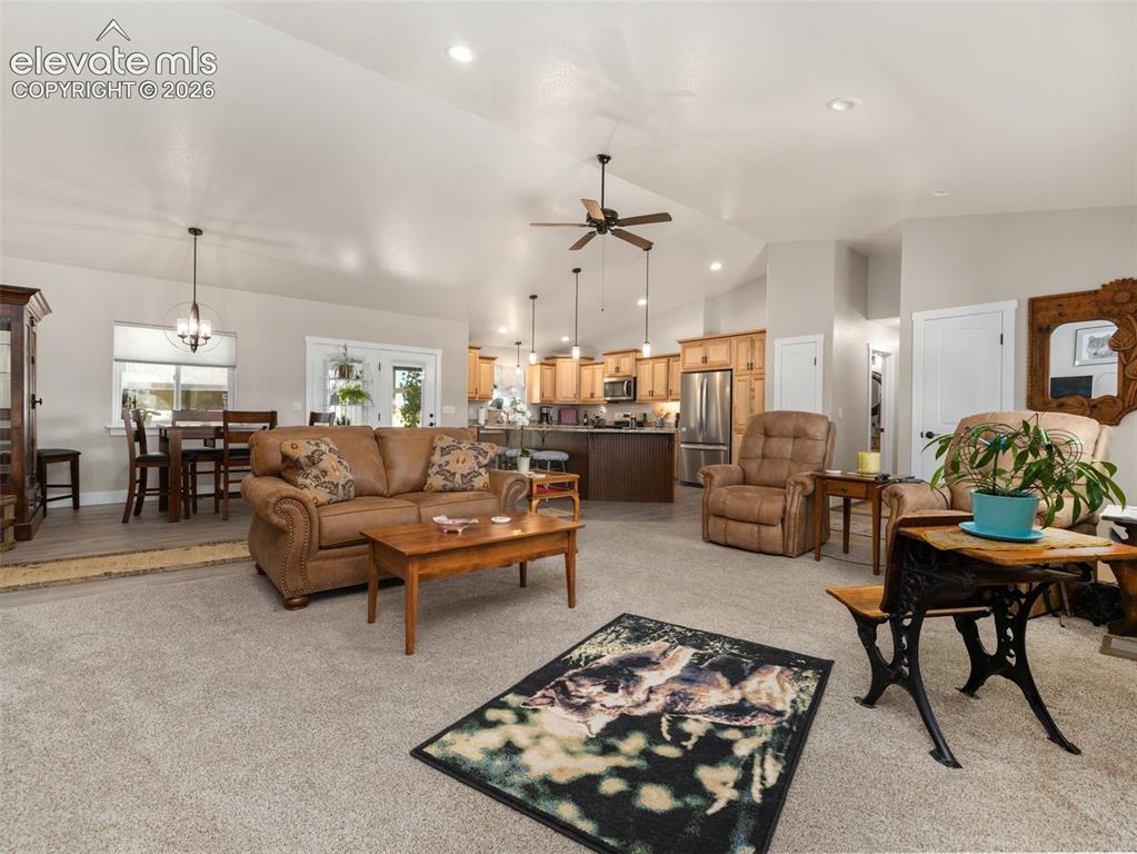 Image 4 of 21: Open-concept living space with vaulted ceilings, recessed lighting, and a c