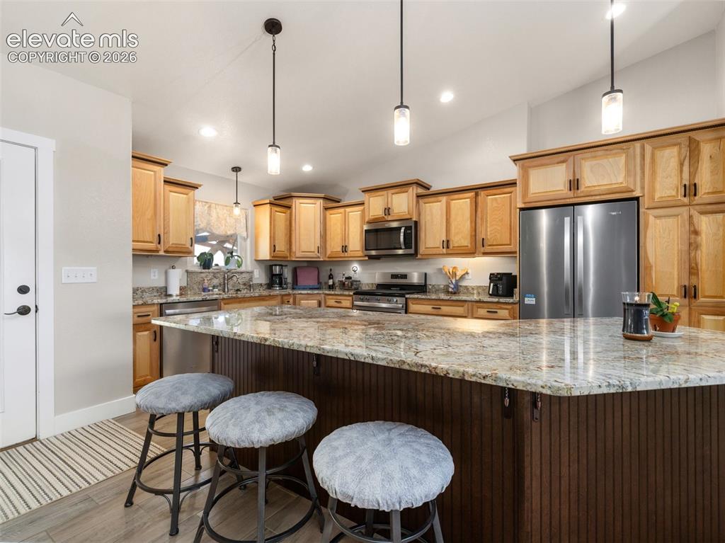Image 7 of 21: Kitchen featuring light wood cabinetry, stainless steel appliances, a large