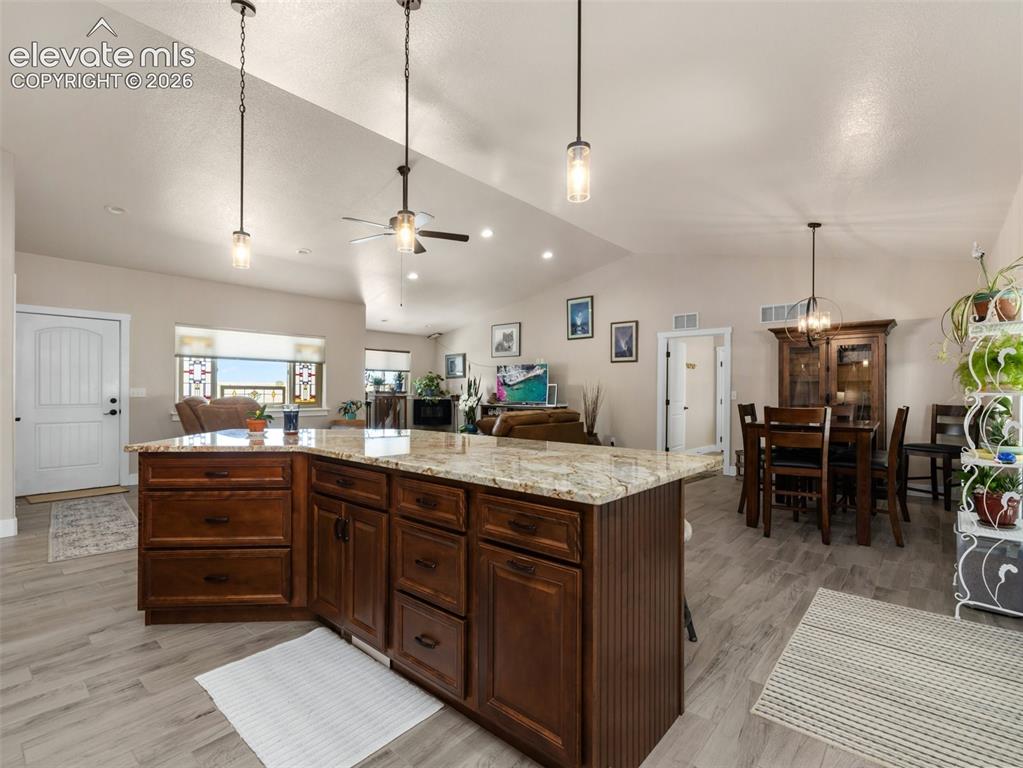 Image 9 of 21: Spacious open-concept living area featuring wood-finish flooring and vaulte