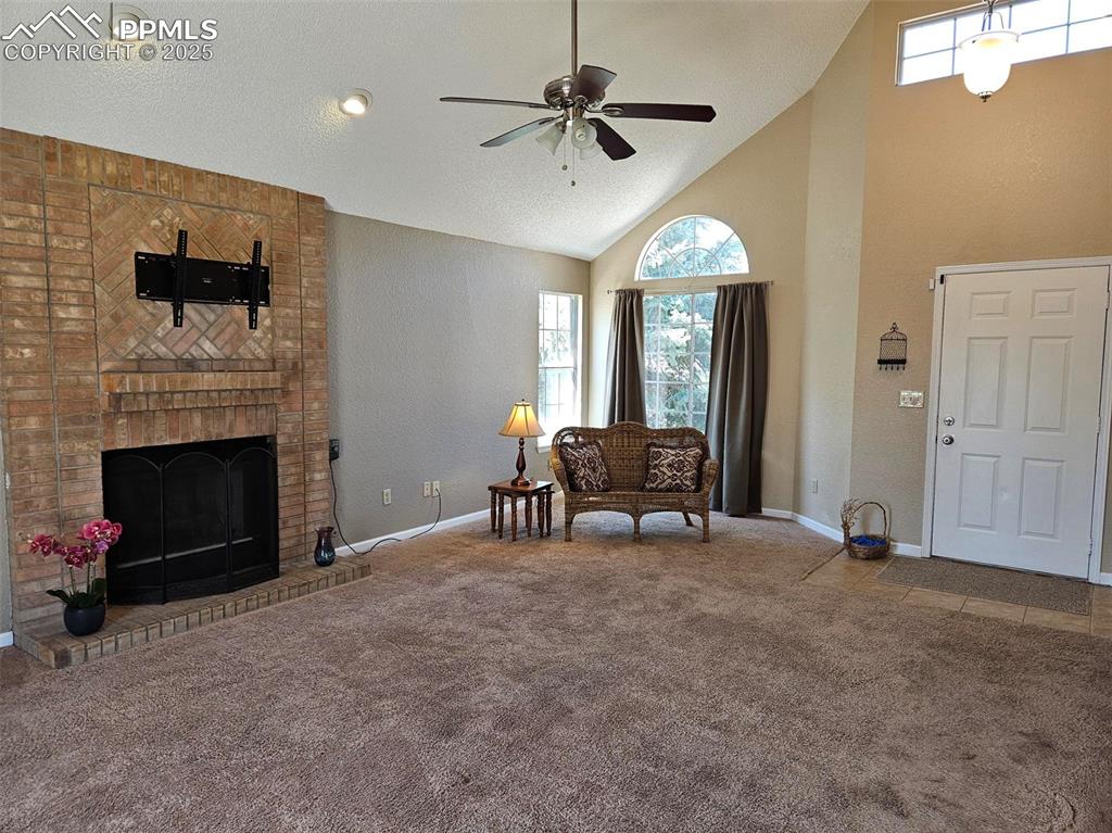 Image 3 of 27: Entry into living room with vaulted ceiling, gas fireplace and tV mount