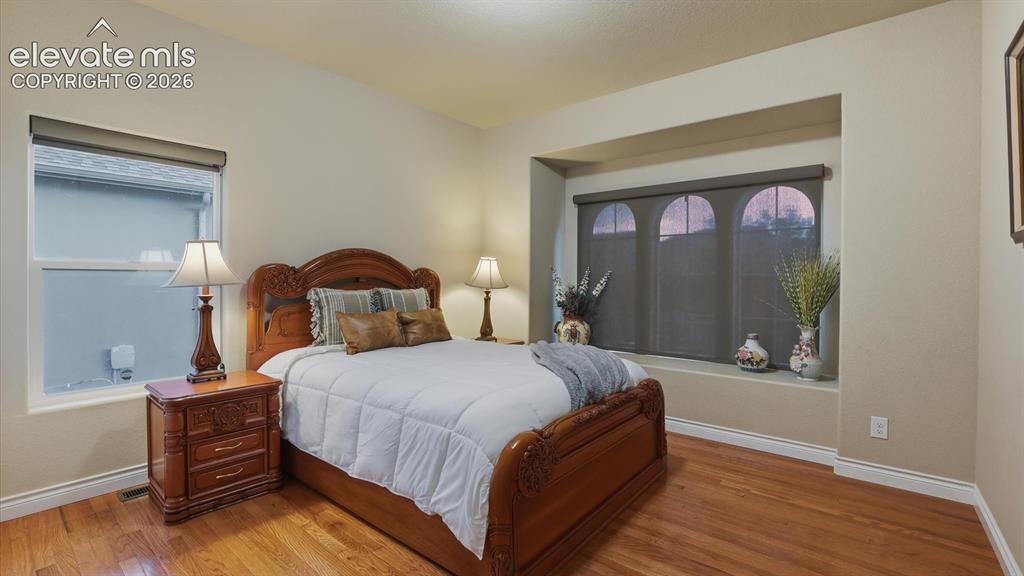 Image 12 of 50: Main Level Bedroom #1 showcases arched windows and a charming window seat,