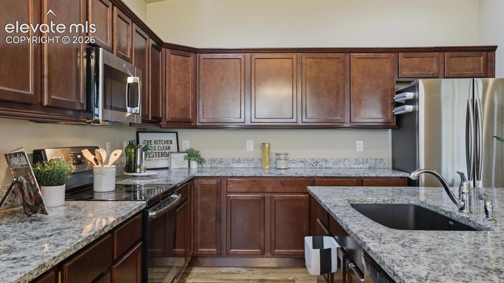 Image 18 of 50: Appliances include a smooth top range oven, microwave oven, dishwasher, and