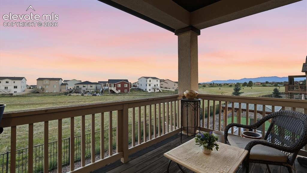 Image 22 of 50: The covered deck overlooks open space with walking/biking trails, and beaut