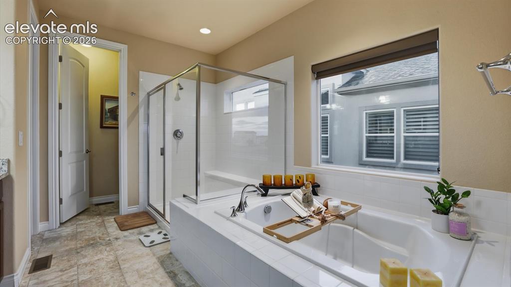 Image 30 of 50: The Primary Bathroom offers a deep soaking tub and separate shower.
