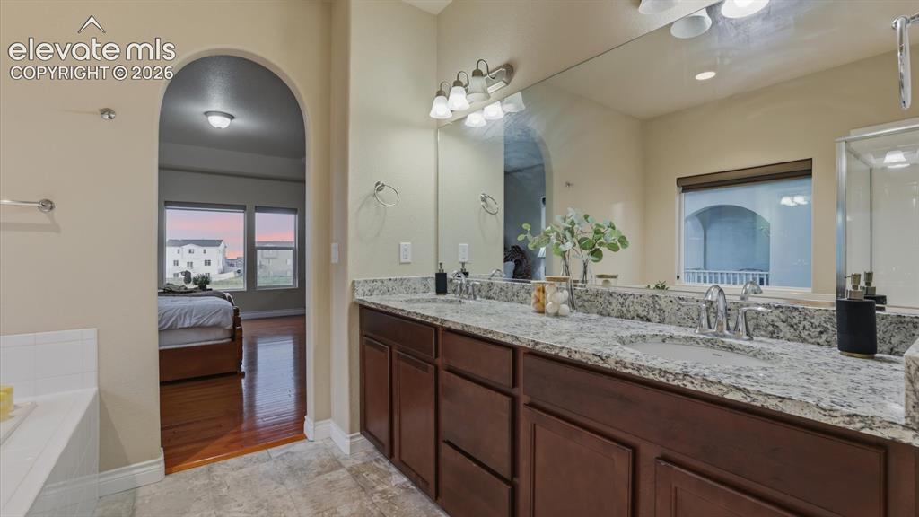 Image 31 of 50: The Primary Bathroom features a dual sink vanity with granite countertops a