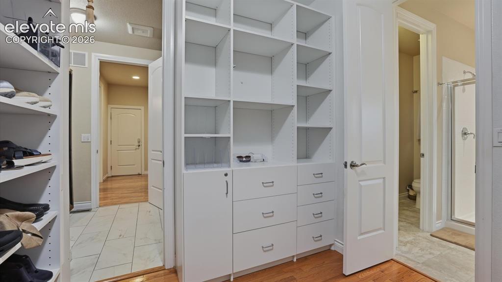 Image 33 of 50: Built-in drawers and shelves in the Primary walk in closet.