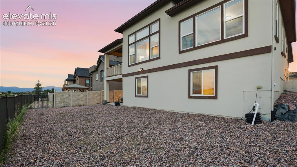 Image 49 of 50: Rear view of xeriscaped backyard.