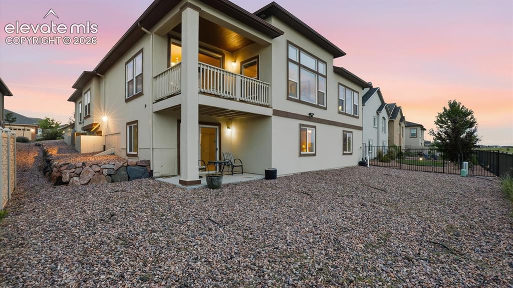 Image 9 of 50: Rear view of home and xeriscaped backyard.