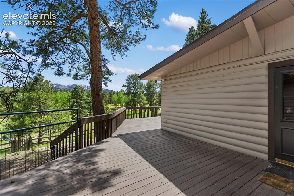 Image 12 of 36: Expansive outdoor deck featuring wood-finish flooring and a wood railing sy