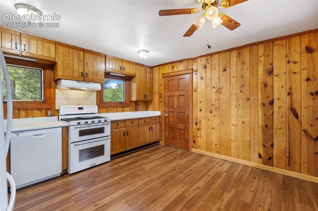 Image 17 of 36: Kitchen featuring wood-finish paneling, wood-finish flooring, and wood cabi