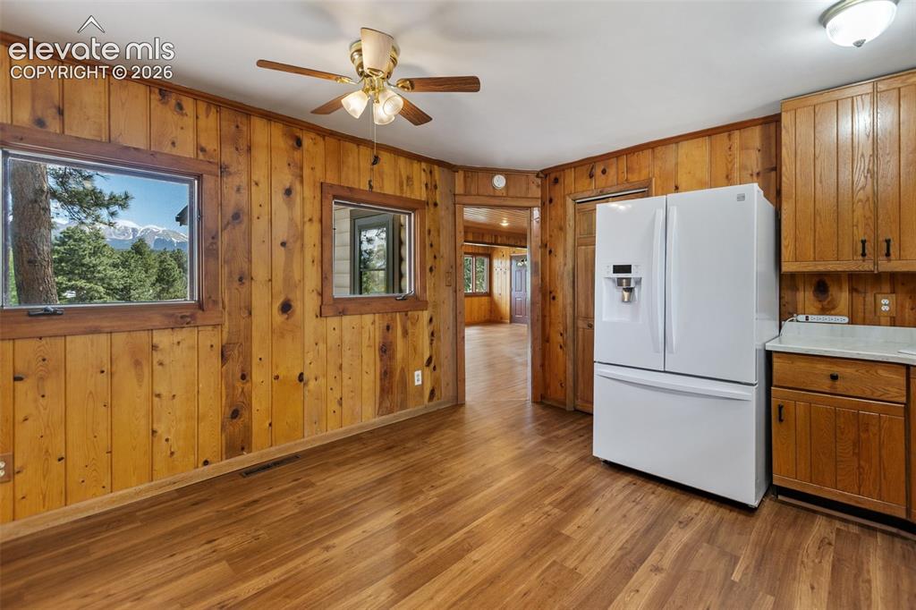 Image 19 of 36: Wood-finish flooring throughout, complemented by wood paneling on the walls