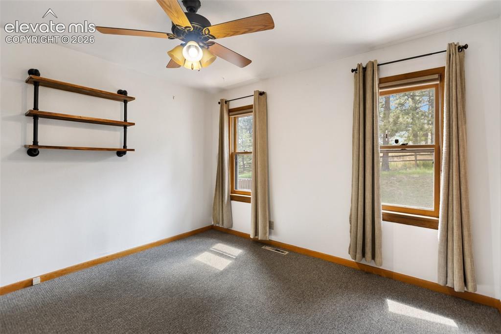 Image 23 of 36: Room featuring two double-hung windows with wooden trim, industrial-style w