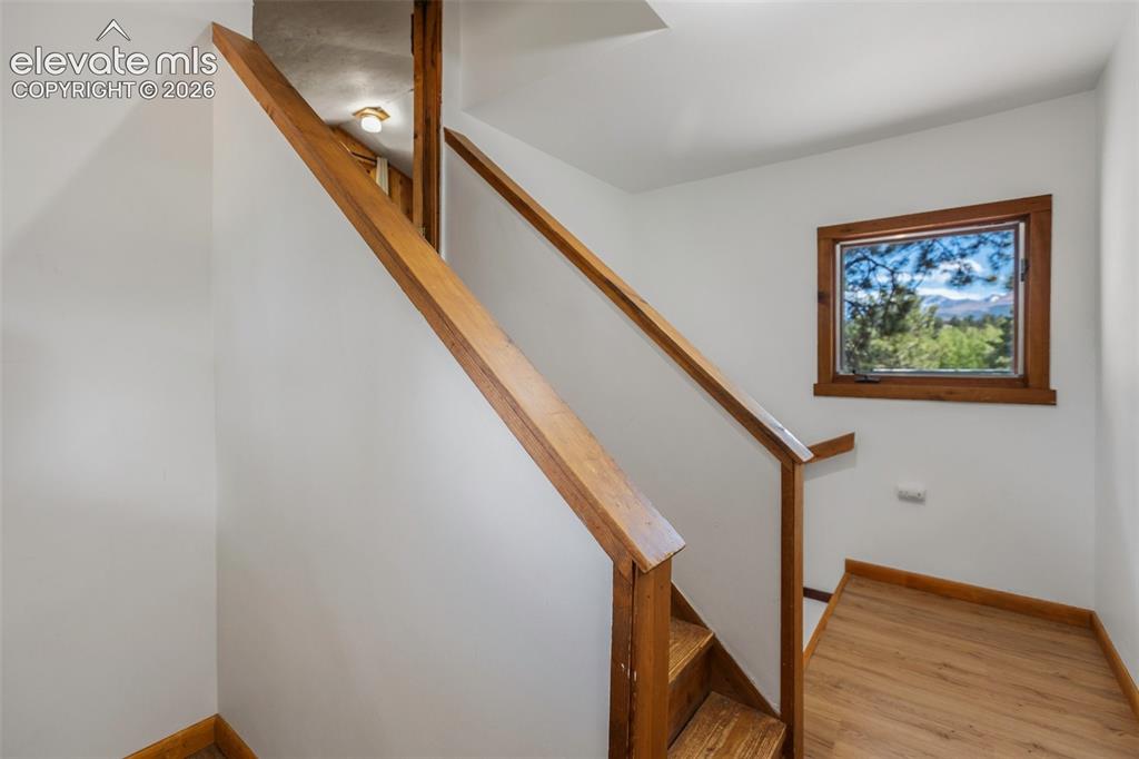 Image 29 of 36: Staircase featuring wood-finish flooring, wood handrails, and a wood-framed