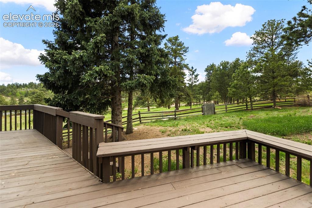 Image 32 of 36: Expansive outdoor deck with integrated bench seating, solid wood railings,