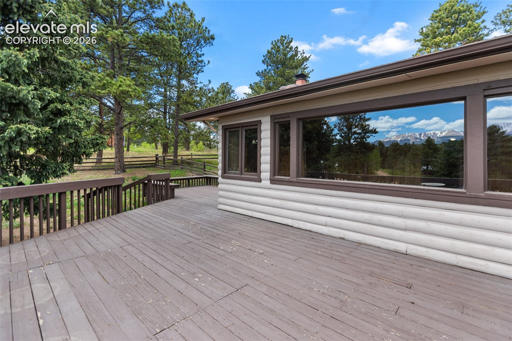 Image 5 of 36: Spacious outdoor deck with wood railing, featuring a log-style exterior, ex