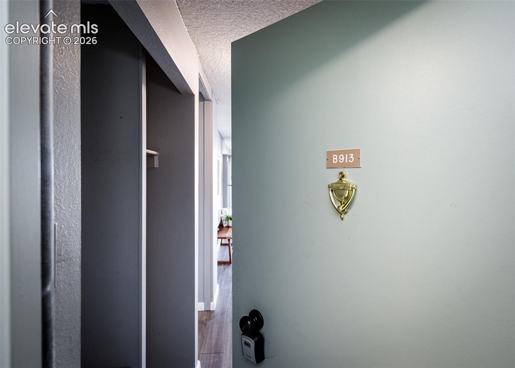 Caption: Entry door with a brass door knocker and unit number