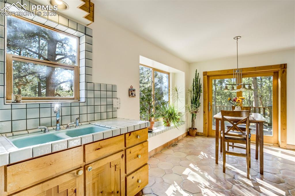 Image 13 of 45: Kitchen featuring tile countertops, backsplash tile flooring.