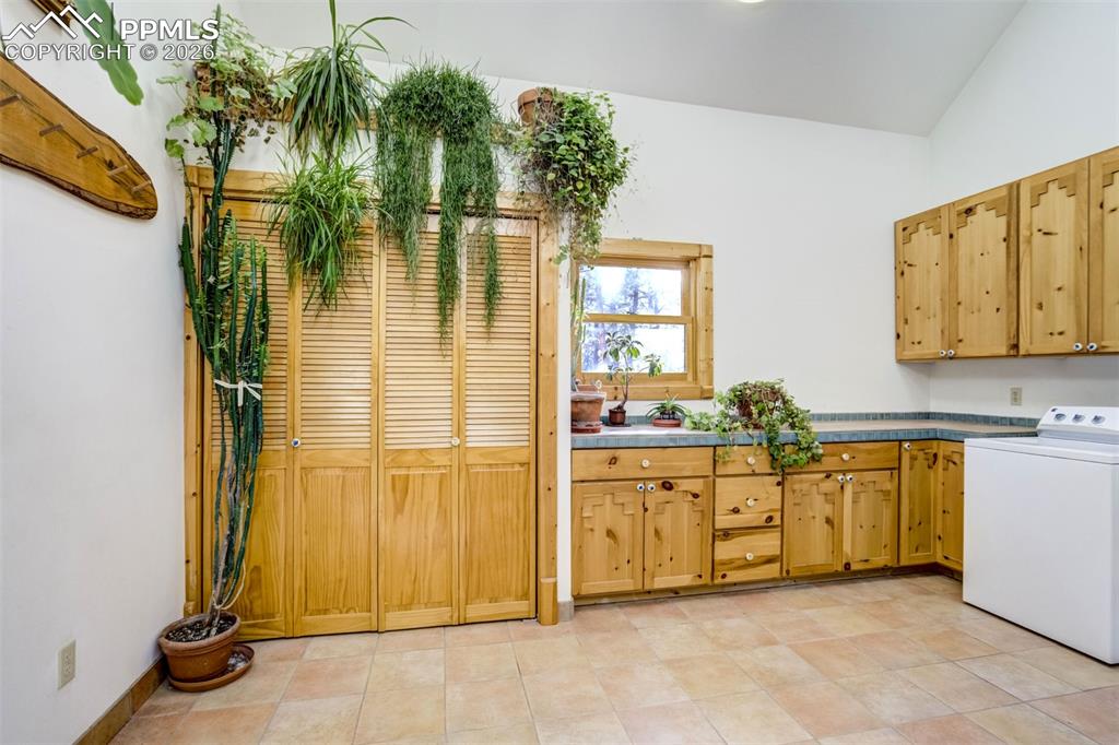 Image 14 of 45: Laundry area with washer / dryer, cabinet space, and lofted ceiling, extra