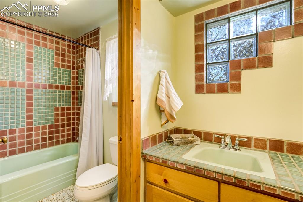 Image 20 of 45: Full bathroom with shower / tub combo with curtain and vanity