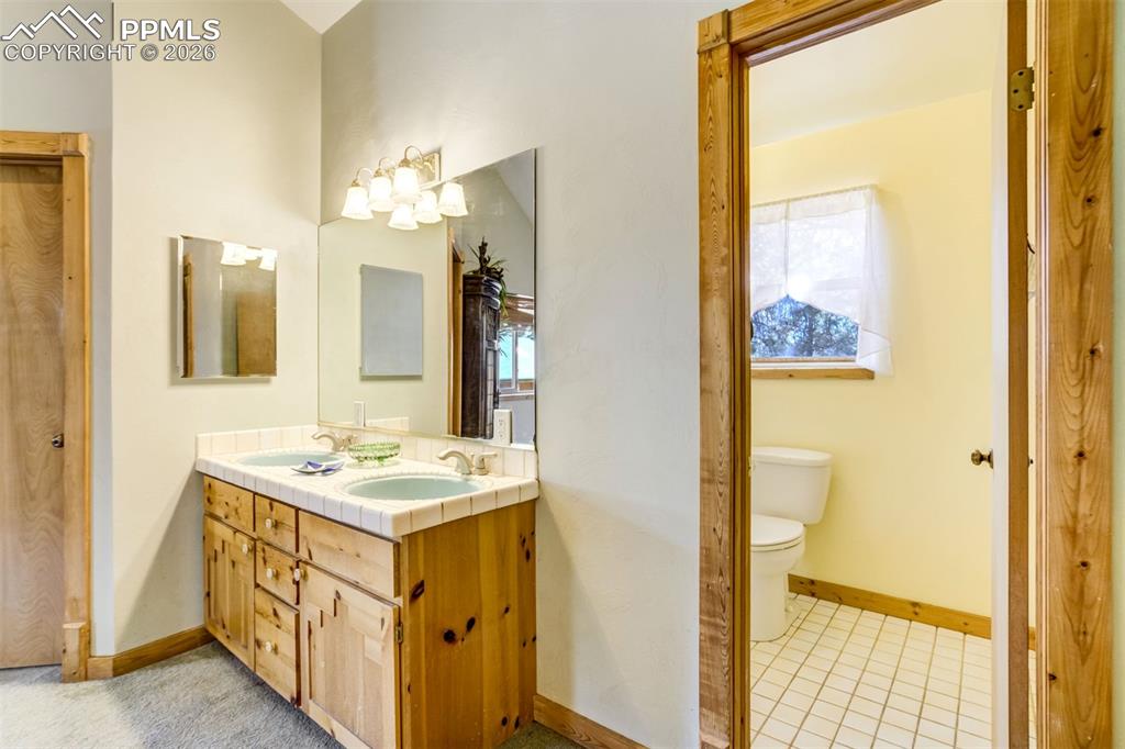 Image 23 of 45: Bathroom featuring double vanity and plenty of natural light