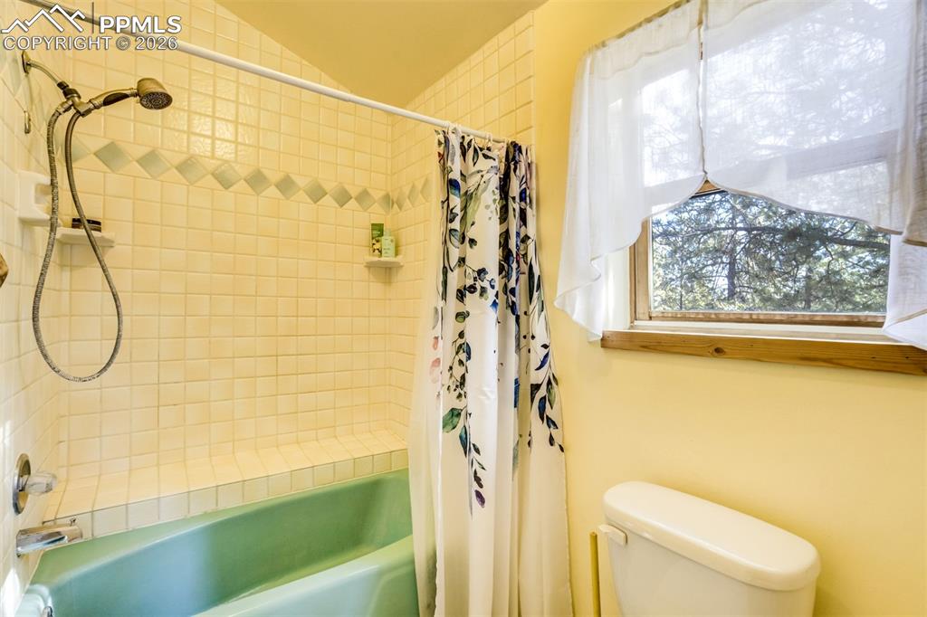 Image 29 of 45: Full bath with shower / tub combo with curtain and toilet