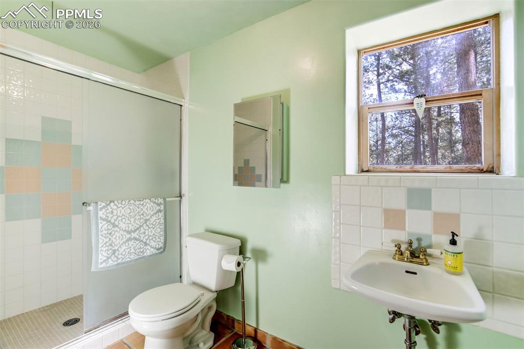 Image 34 of 45: 3/4 bath with healthy amount of natural light, a stall shower, and fun back