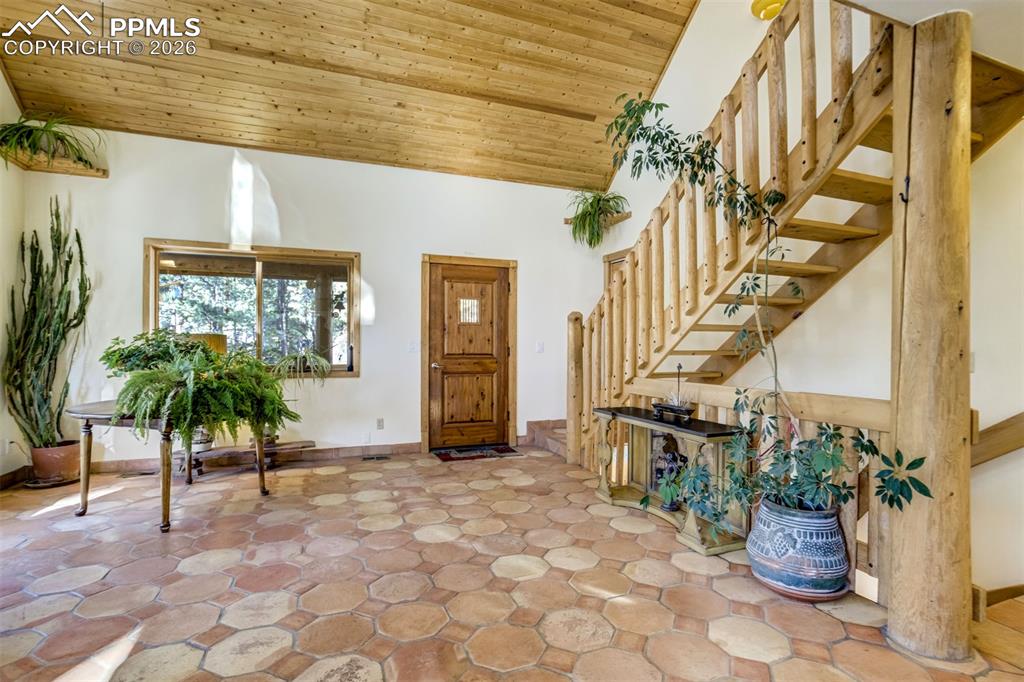 Image 8 of 45: Foyer with stairs and a vaulted wood ceiling
