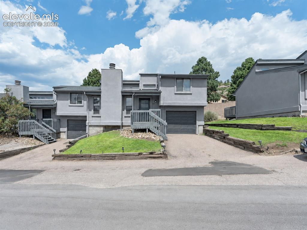 Image 1 of 28: Multi-level townhome exterior featuring an attached garage, private deck ac
