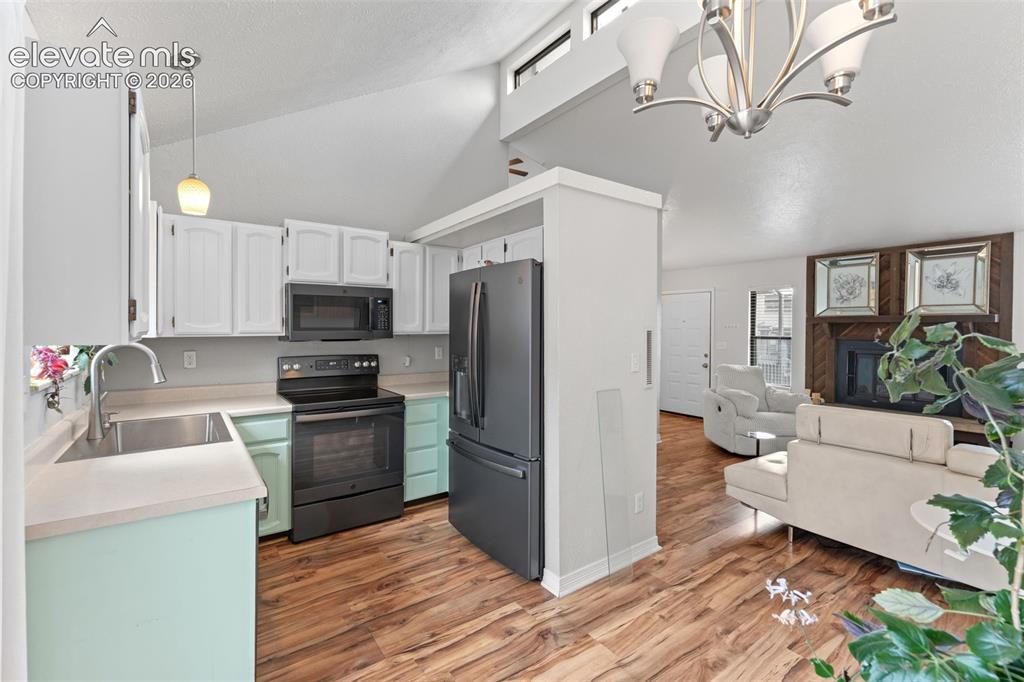 Image 10 of 28: Vaulted ceilings with clerestory windows, wood-finish flooring, a kitchen f