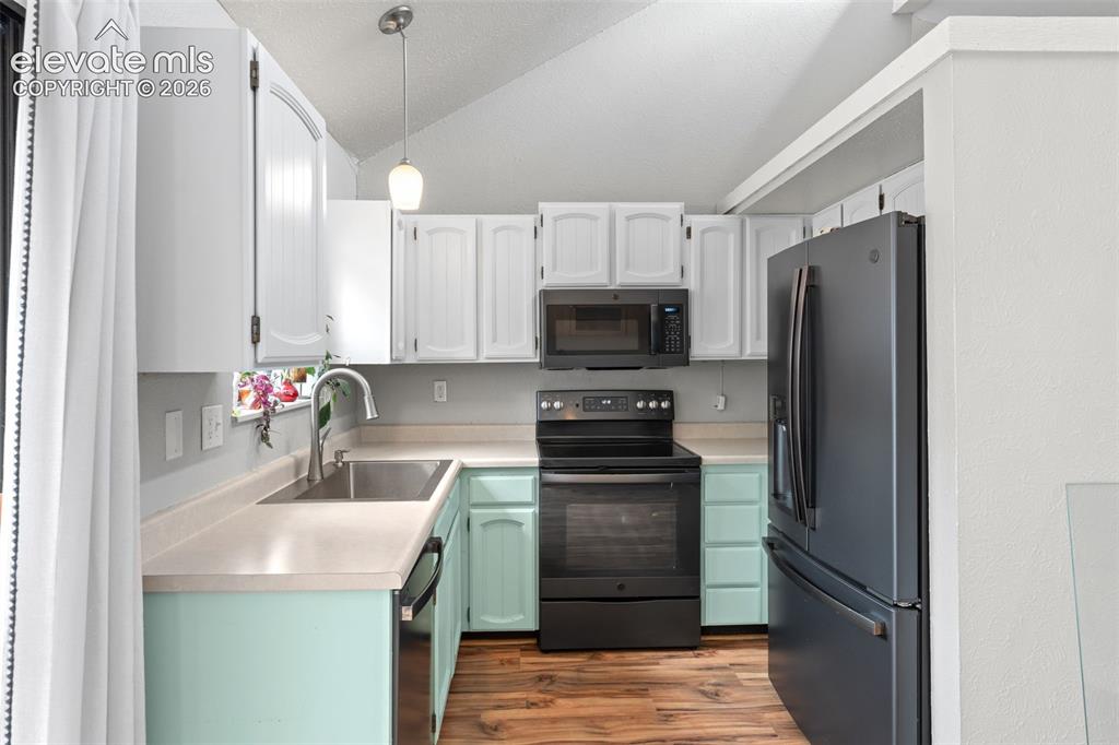 Image 13 of 28: U-shaped kitchen featuring white upper cabinetry, mint green lower cabinetr