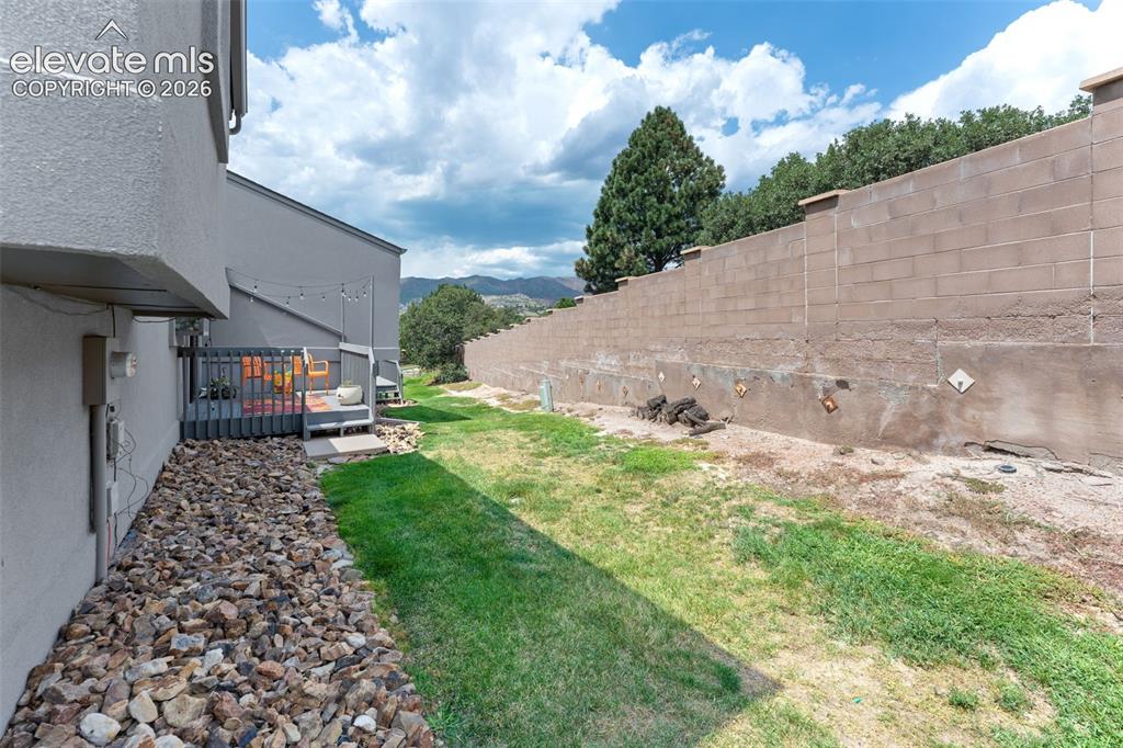 Image 16 of 28: Outdoor patio with a privacy fence and a gravel landscaping strip